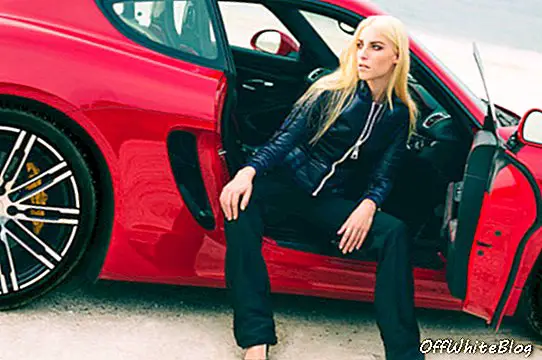 Das Modell trägt eine Nylonjacke und eine Hose mit Kordelzug von Louis Vuitton. Patent Plattform Stilettos von Saint Laurent. Das vorgestellte Auto ist ein 911 Carrera GTS in Carmine Red