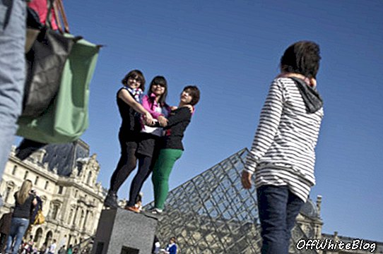Turis berpose untuk foto di Carrousel du Louvre di Paris